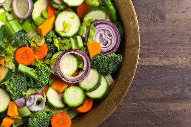 Taze çiğ sebze eski ahşap masanın üzerine dilimlenmiş.