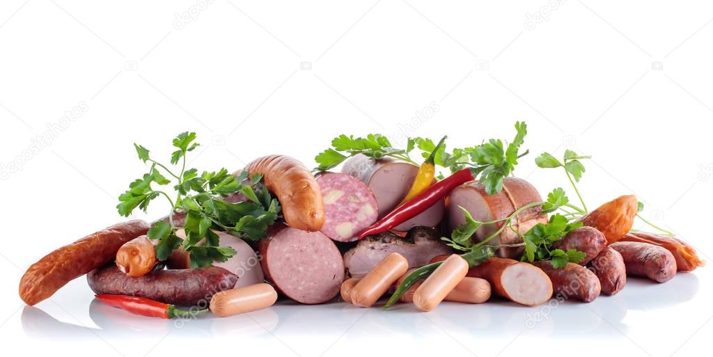 Different sausages and smoked meats isolated on white .