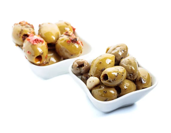 Kryddad gröna oliver i olja isolerad på vit . — Stockfoto
