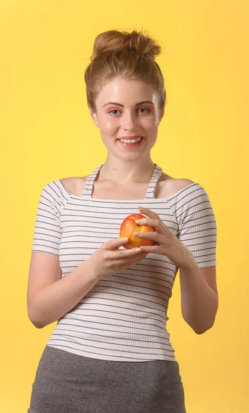 Mujer atractiva joven con sonrisa blanca como la nieve sosteniendo manzana roja . — Foto de Stock