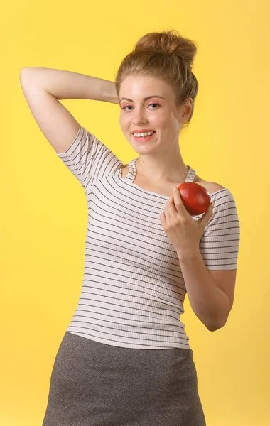 Young attractive woman with snow-white smile holding red apple. — Stock Photo, Image