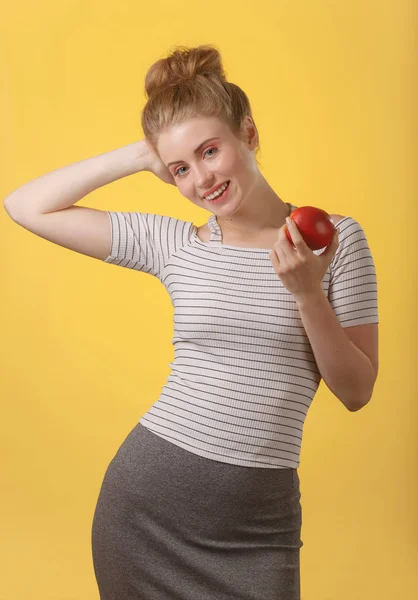 Mujer atractiva joven con sonrisa blanca como la nieve sosteniendo manzana roja . — Foto de Stock