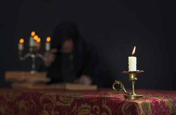 Kerze auf dem Hintergrund des lesenden Mönchs. — Stockfoto