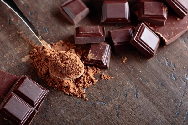 Morceaux de chocolat cassés et poudre de cacao  . — Photo