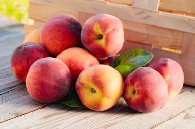 Ahşap rustik arka plan üzerinde yaprakları ile taze şeftali.