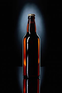 Kapalı şişe bira siyah bir zemin üzerine.