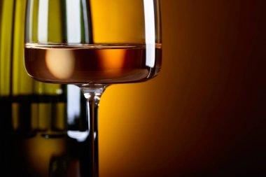 Cam ve sarı bir arka plan üzerinde beyaz şarap şişe. 