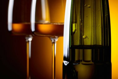 Gözlük ve sarı bir arka plan üzerinde beyaz şarap şişe. 