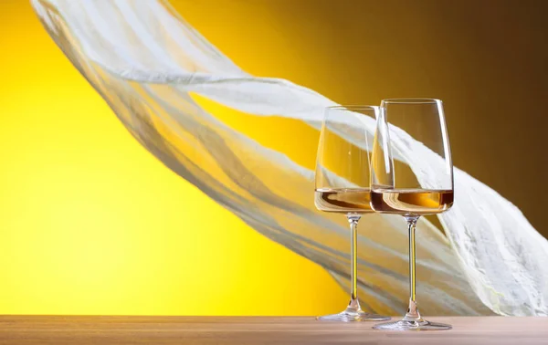 Gläser Weißwein auf gelbem Hintergrund. — Stockfoto