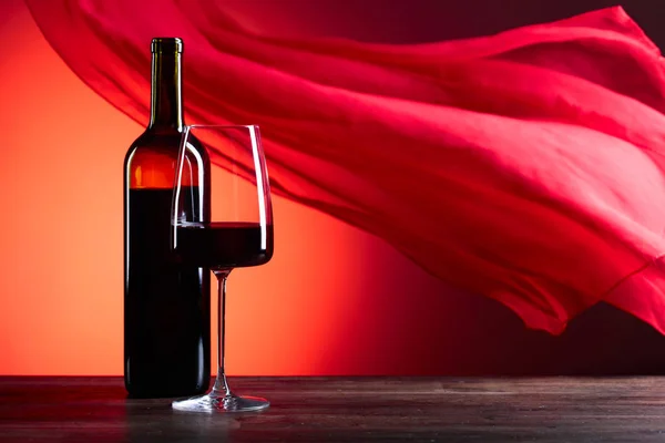 眼镜和瓶的忠告葡萄酒在红色的背景。红色纯粹 f — 图库照片