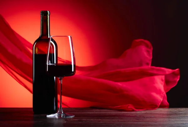 メガネと赤い背景の上の助言のワインのボトル。赤の薄い f — ストック写真