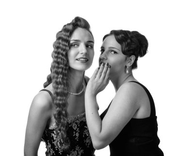 Two young women whispering gossip on white background. clipart