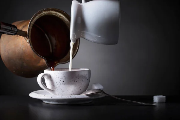 Горячий кофе и молоко наливают в чашку  . — стоковое фото