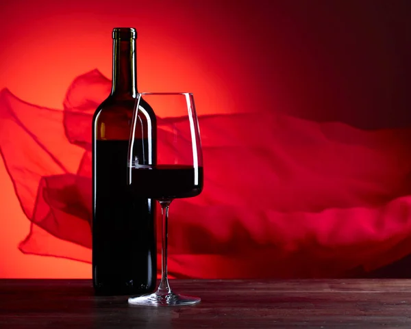 Bicchieri e bottiglia di vino rosso su fondo rosso. Rosso puro f — Foto Stock