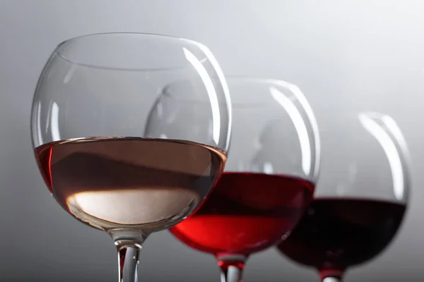 Glasses of  pink , red and white wine .