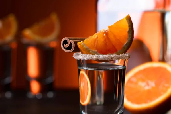 Tequila-Gläser mit Orangen- und Zimtstangen auf einem Holz-T — Stockfoto