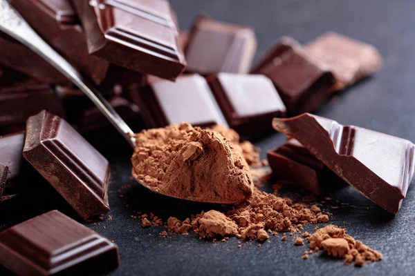 Broken chocolate pieces and cocoa powder. — Stock Photo, Image