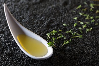 Bitki Yağ kekik dalları bir arka plan üzerinde siyah susam ile.