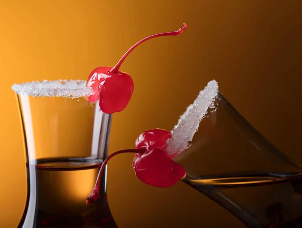 Sweet cherries and glasses of liquor. — Stock Photo, Image