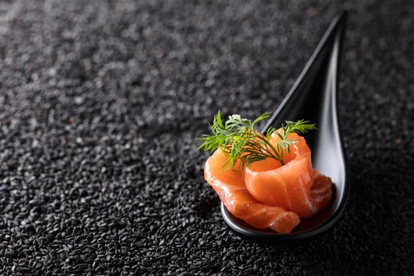 Gravlax med dill på bakgrunden av svarta sesamfrön. — Stockfoto