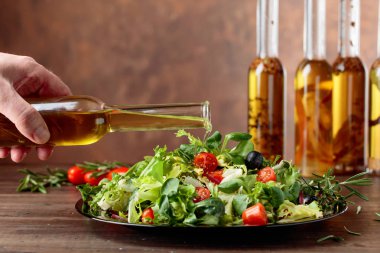 Dökme küçük bir şişe zeytinyağı ile yeşil salata. 