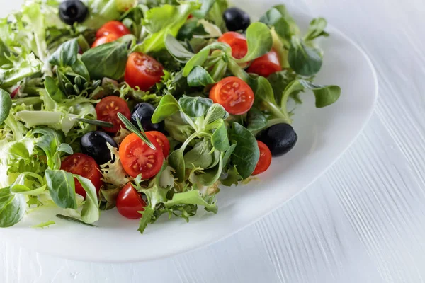 Grön spring sallad med tomater och svarta oliver. — Stockfoto