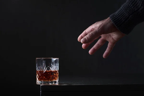 Mannens hand når för ett glas alkohol. — Stockfoto