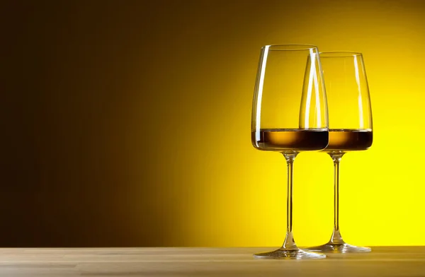 Szklanki białego wina na żółtym tle. — Zdjęcie stockowe