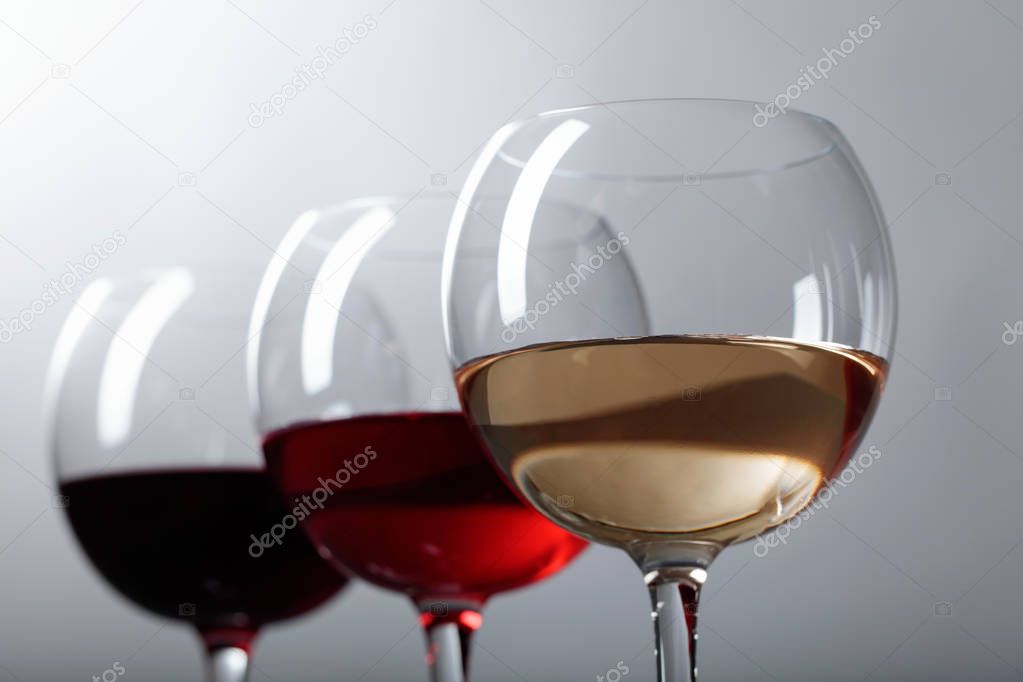 Glasses of  pink , red and white wine .