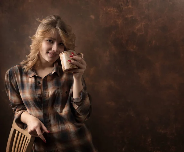 Hübsche Frau mit langen blonden Haaren im braunen karierten Hemd hält Co — Stockfoto