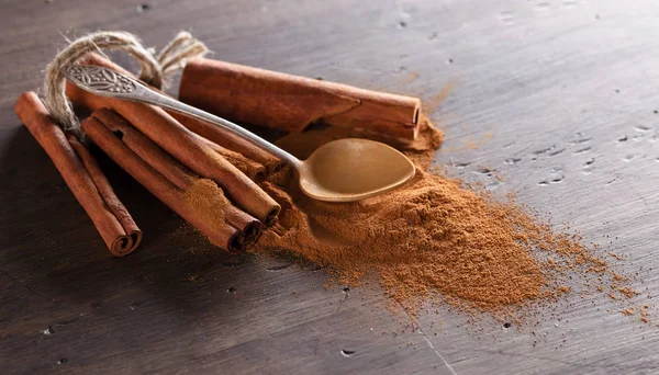 Cinnamon sticks and powder in small spoon. — Stock Photo, Image