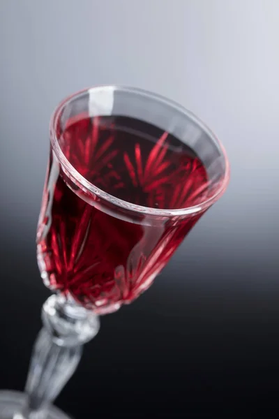 Close-up of crystal glass with red wine on dark background. — Stock Photo, Image