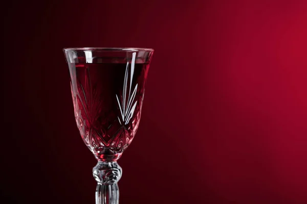 Gros plan du verre de cristal avec du vin rouge sur fond sombre . — Photo