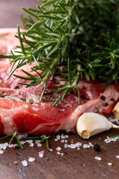 Rauw varkensvlees met rozemarijn, peper en zout. — Stockfoto