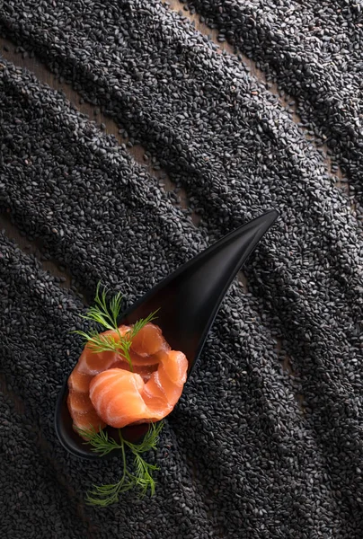 Salmone salato con aneto sullo sfondo di sesamo nero . — Foto Stock