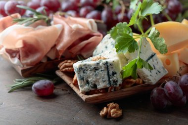 Çeşitli peynirler, üzüm ve prosciutto .