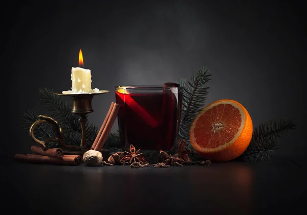 Vino caliente con naranja, especias y vela encendida en latón viejo —  Fotos de Stock