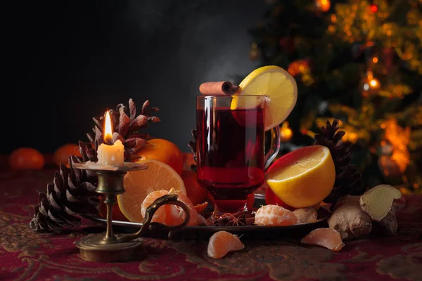 Vinho amontoado com citrinos, especiarias e vela acesa em latão velho — Fotografia de Stock