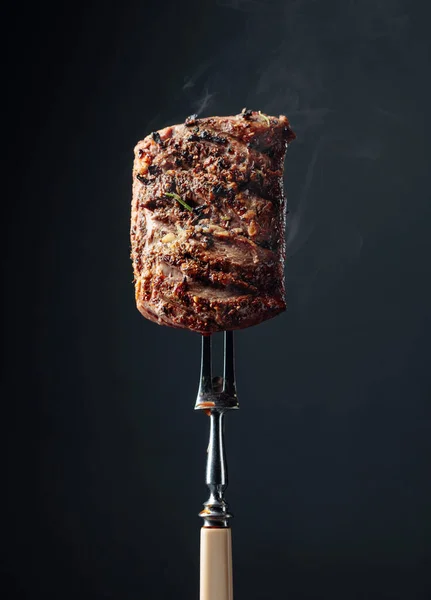 Grilled ribeye beef steak met rozemarijn op een zwarte achtergrond. — Stockfoto