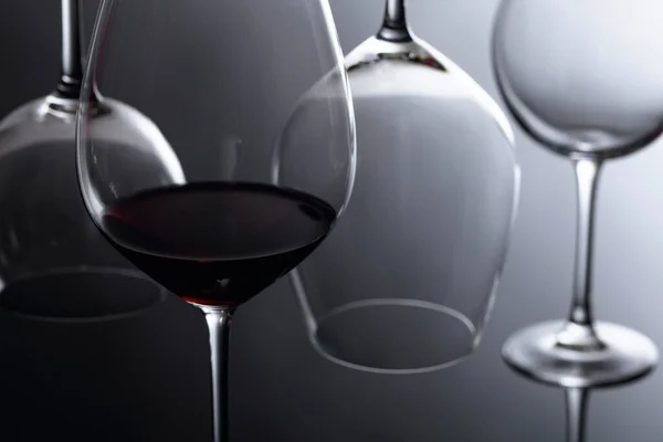 Copo de vinho tinto sobre um fundo reflexivo preto . — Fotografia de Stock