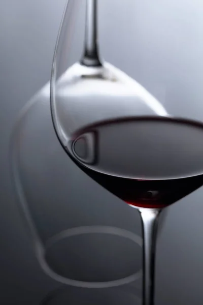 Склянка червоного вина на чорному відбиваючому фоні . — стокове фото