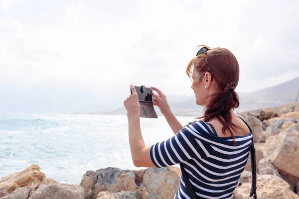 Привлекательный зрелый путешественник женщина использовать мобильный телефон сфотографировать — стоковое фото
