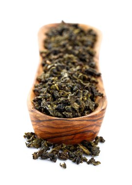 Küçük ahşap çanakta yeşil çay, beyaz tencerede izole edilmiş..