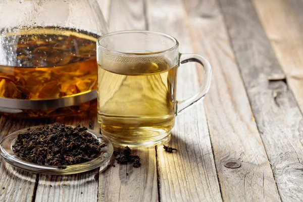 Heißer grüner Tee im Glasbecher. getrocknete Teeblätter und heißes Getränk auf einem — Stockfoto