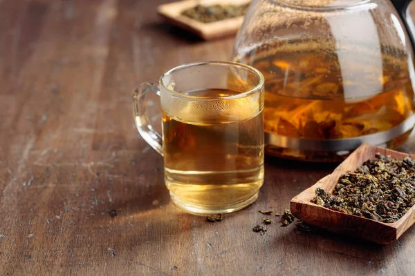 Chá verde quente em caneca de vidro. Folhas de chá secas e bebida quente em um — Fotografia de Stock