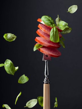 Dilimlenmiş sosis ve yeşil fesleğen yaprağı..