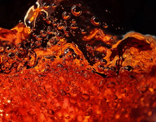 Alcoholic drink on a dark background, abstract splashing. — Stock Photo, Image