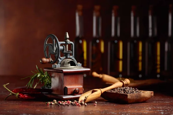 Antico macinapepe con utensili da cucina, bottiglie di olio d'oliva, spi — Foto Stock