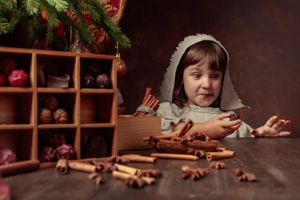 Kleines Mädchen in einem Vintage-Leinenkleid neben dem Tisch mit Süßigkeiten — Stockfoto