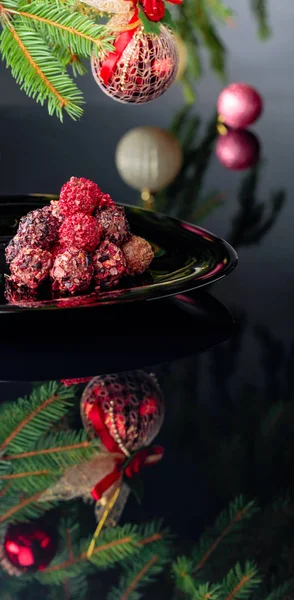 Truffes au chocolat sur une assiette noire et sapin de Noël . — Photo